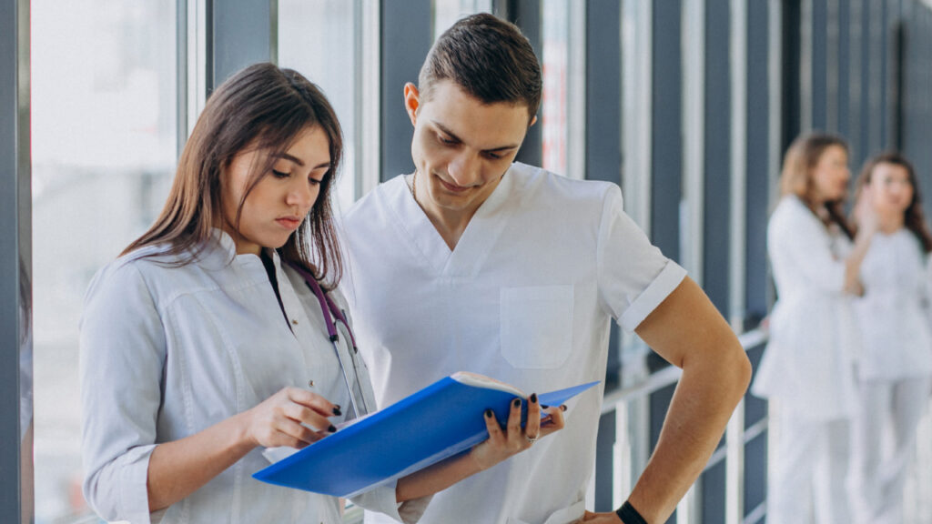 Two engineers at NPX Medical review a medical device research and development portfolio for a prototype.